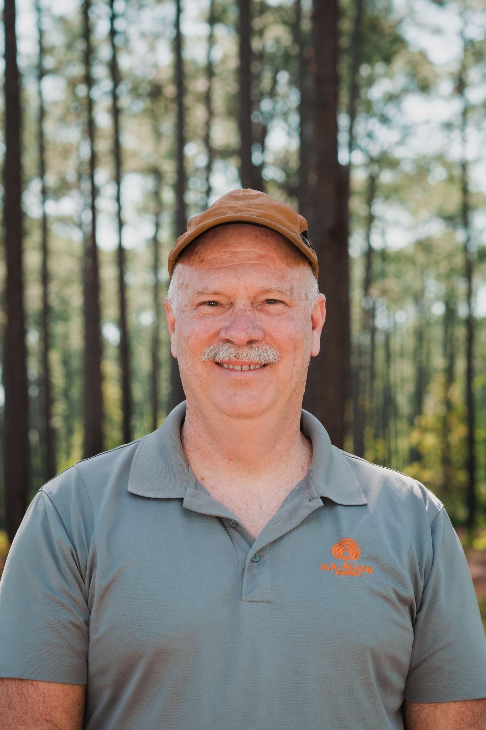 man in front of wood