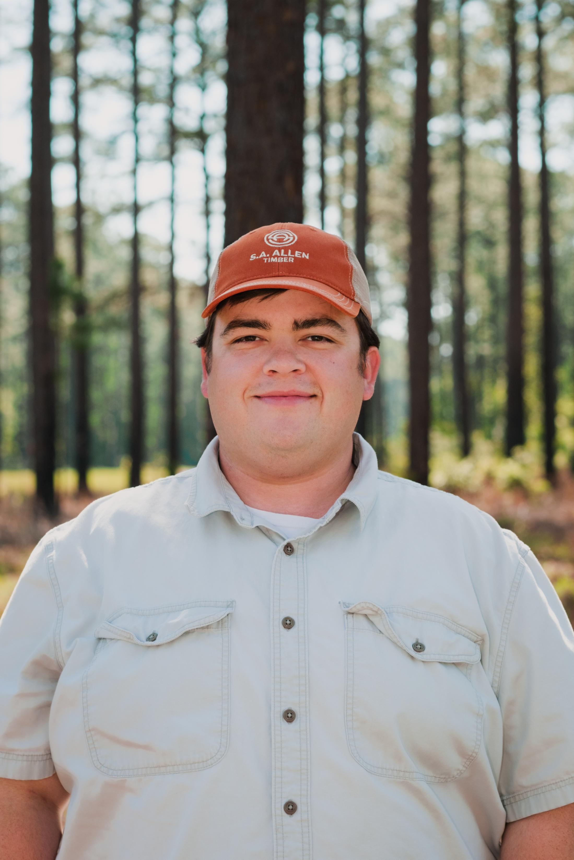 man in front of wood